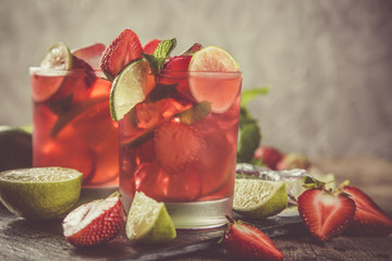Strawberry mojito and ingredients on rustic background