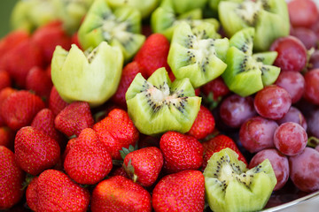 Fresh fruits on plate. Strawberries, kiwi, grapes on catering banquet table. Selective focus