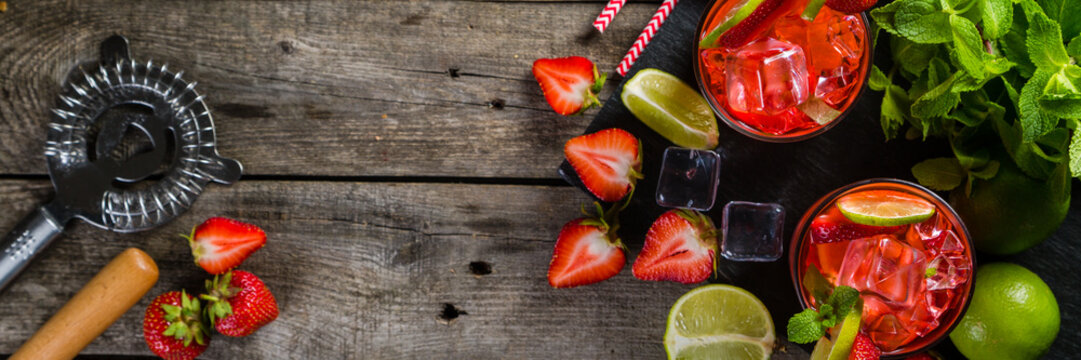 Strawberry mojito and ingredients on rustic background