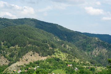 Fototapeta na wymiar Village in mountains landscape - green nature