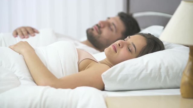 The couple sleeping in the bed