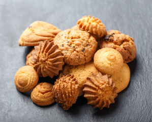 Assorted cookies with chocolate chip, oatmeal raisin on stone slate background on wooden background close up. Homemade baking. Top view, flat lay
