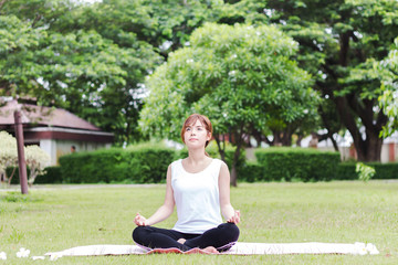 Young woman doing yoga in morning park