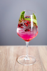 Light Pomegranate Cocktail Decorated with Raspberry Syrup, Mint and Ice, Cold Drink, Vertical View