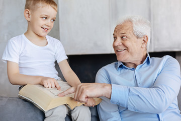 Obraz premium Wise elderly man explaining something to his grandson