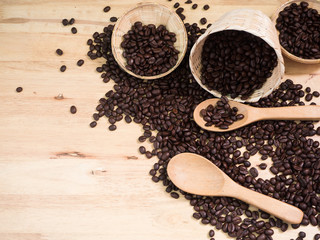 coffee beans in basket weave and wood spoon on wood table