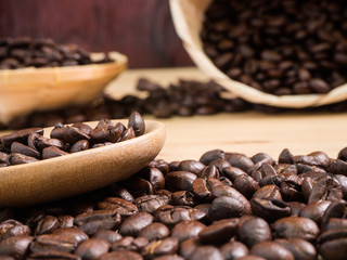 coffee beans in basket weave and wood spoon on wood table