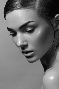Beautiful young well-groomed girl in profile. Face - close-up. Makeup is natural. Hairstyle - straight parting. Black and white photography.