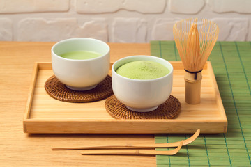 Matcha green organic tea cup and powder on wooden table
