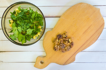 Preparation of a vegetarian salad. Cutting walnuts