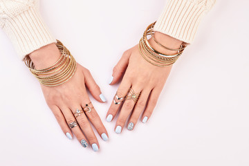 Gold and silver jewelry on women's hands.