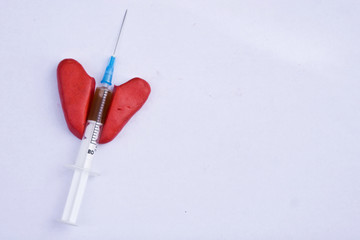Syringe in a broken heart closeup