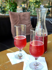 Summer lemonade with raspberry and leaves mint in a glass jug