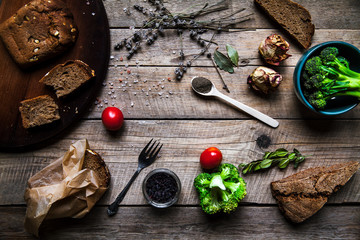 Fresh bread with vegetables and spices on wooden background. Food, empty space for text.