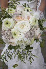 Peachy pinks, white, and green bridal bouquet with Juliet garden roses, O’Hara garden roses, gerondo gerbera daisies, rice flower, privet berries, Jasmine vine