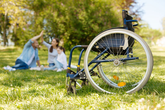 Focused photo on the wheelchair that standing empty on the foreground