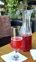 Summer lemonade with raspberry and leaves mint in a glass jug