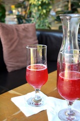 Summer lemonade with raspberry and leaves mint in a glass jug