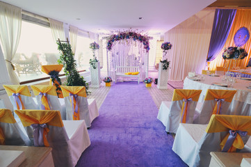 decor of the banquet room on a wedding in yellow and lilac, violet tones