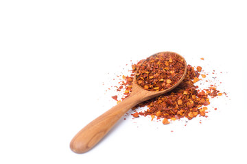 powder and dried chili peppers on wooden spoon isolated on white background