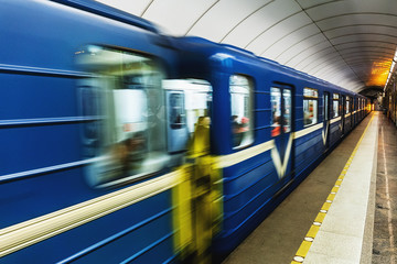 Blue subway train arrives at the station