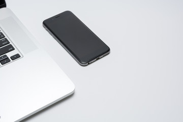 Laptop computer with smart phone on white background