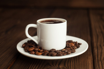 Coffee cup and coffee beans on wooden table. Front view