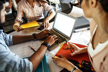 Group of casual architects and designers working on new project .They using laptop and discuss...