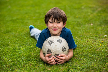 Smiling young boy holding soccer ball