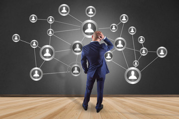 Businessman in front of a wall with a business network connection - business concept