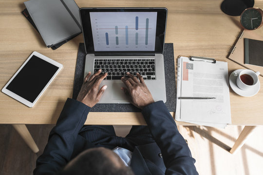 Overhead view of businessman working on laptop in office