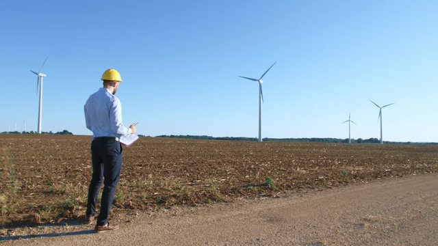 The engineer begins work on the drawings against the background of windmills