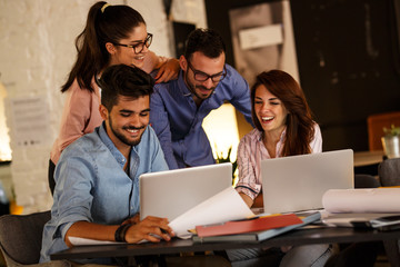 Group of casual concept designers working on new project .They using laptop and discuss about concept.Solving problems with positive attitude.