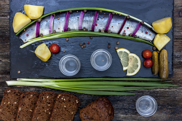 Russian feast with herring, onions, potatoes and vodka