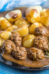 Homemade fried meatballs served with potatoes and cabbage.