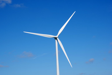 Fototapeta premium Gros plan d'une éolienne sur un magnifique ciel bleu, France