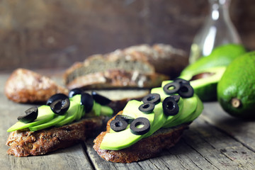 avocado bread olives on a wooden background