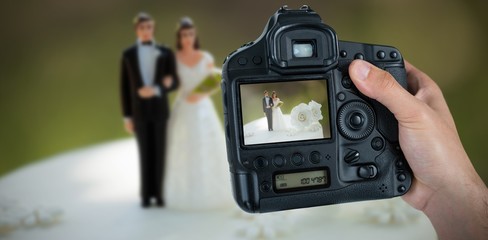 Composite image of cropped hand of photographer holding camera 