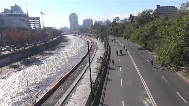 People cycling along a river in Santiago, Chile