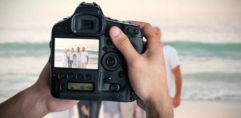 Composite image of cropped image of hands holding camera 