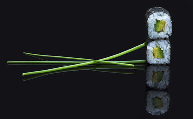 Sushi arranged on a shiny black surface looking delicious