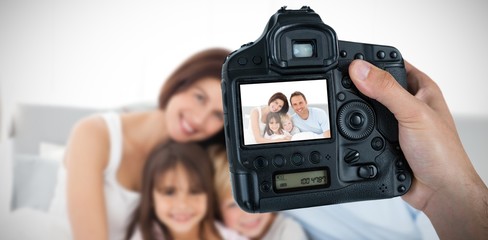 Composite image of cropped hand of photographer holding camera 