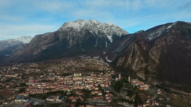Flight over a town next to Alps in Northern Italy