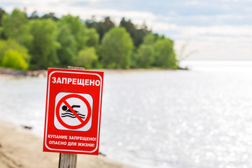 Warning sign on the river - bathing is forbidden, dangerous to life
