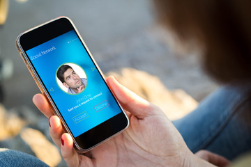 woman sitting in the street holding her smartphone friendship request