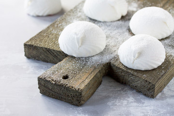 Fototapeta na wymiar Delicate vanilla marshmallows on a vintage stone background.