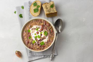 Healthy bean soup in a bowl on concrete background. Top view.