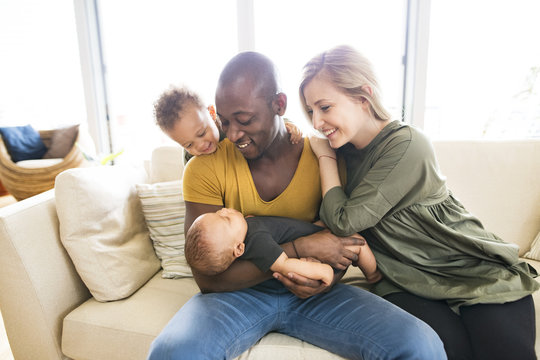 Young interracial family with little children at home.