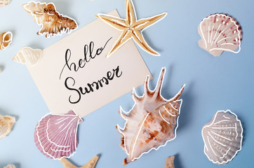 Creative layout made of different colorful seashells and greeting card with Hello Summer Lettering