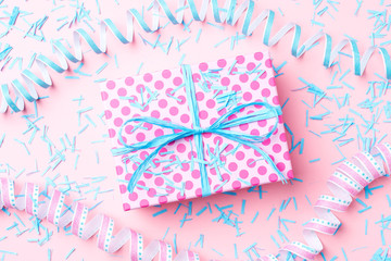 Birthday background with pink dotted gift box, serpentine and confetti. Close up